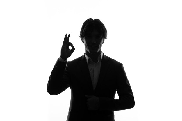 Silhouette of man in strict suit seems delighted shadow back lit white background