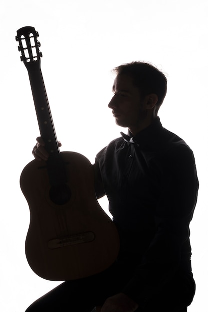 Foto gratuita silhouette di un uomo con la chitarra acustica