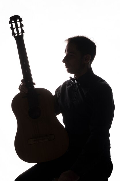 silhouette of a man with acoustic guitar