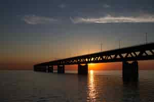 Free photo silhouette of the öresundsbron bridge over the water