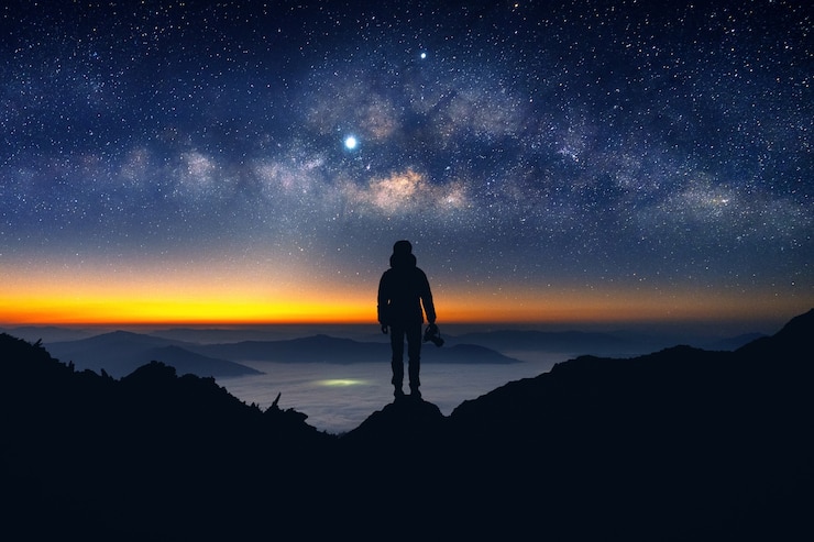 Free Photo silhouette of photographer with camera and milky way blackground.