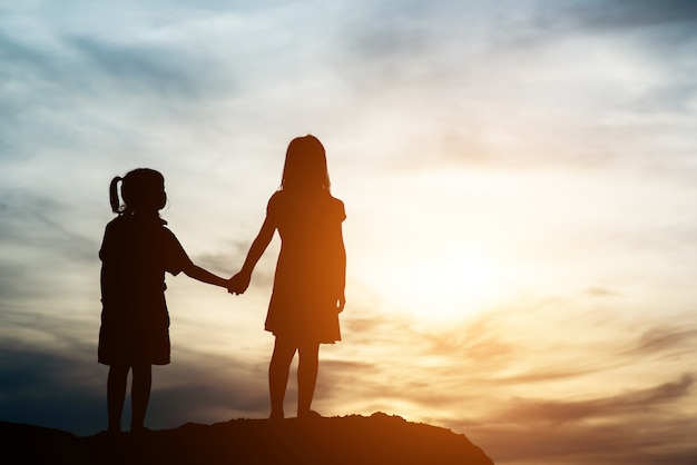 Free photo silhouette of two girl having fun in nature