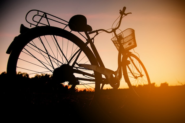 Foto gratuita silhouette di bici d'epoca al tramonto