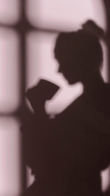 Silhouette of woman at home with window shadows