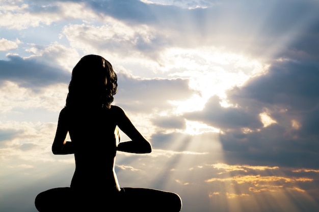 Free photo silhouette of woman practicing yoga