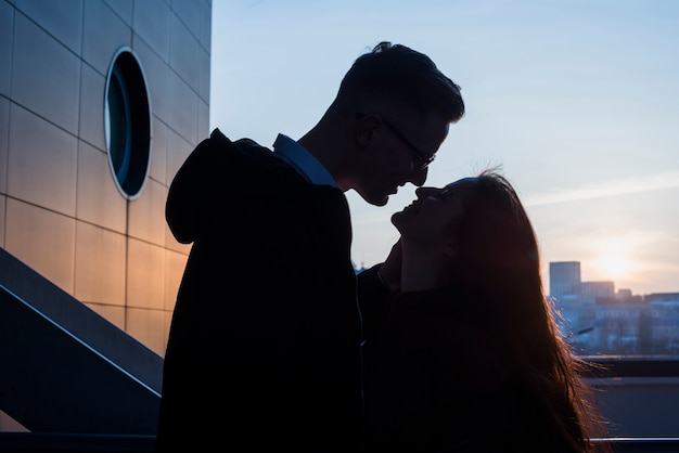 Free photo silhouette of a young couple loving each other at outdoors