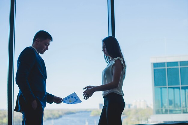 Silhouettes of ceo and business woman in front of a window