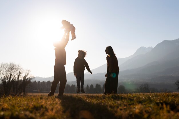 Sagome di famiglie in natura al tramonto