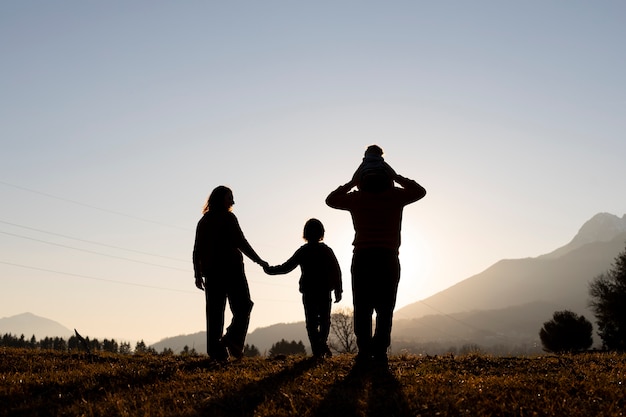 silhouettes of families in nature at sunset