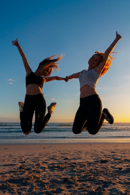 Free photo silhouettes of people jumping at sunset