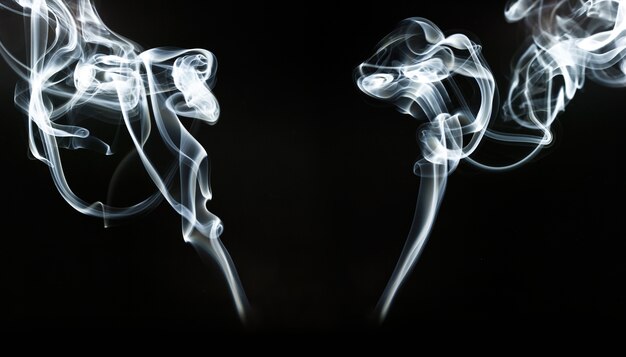 Silhouettes of white smoke on black background