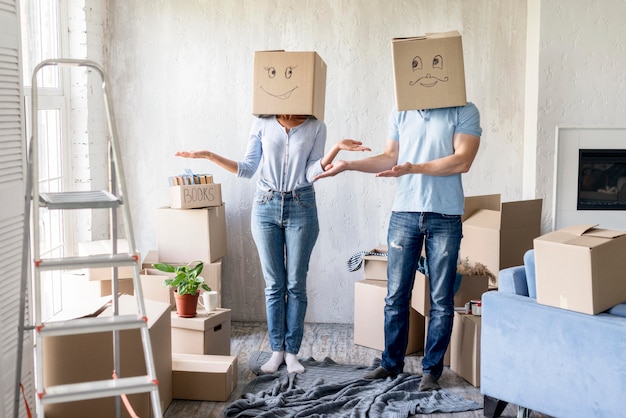 Silly couple with boxes over heads on moving out day