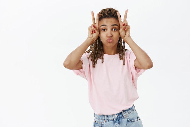 Silly and cute african-american girl showing peace gesture