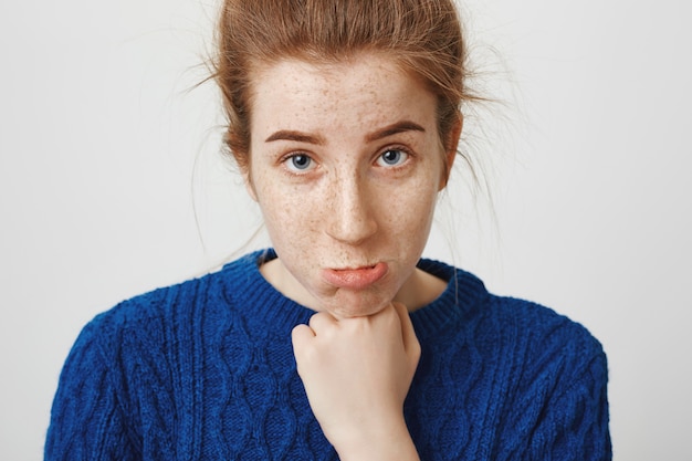 Free photo silly cute redhead girl making innocent face