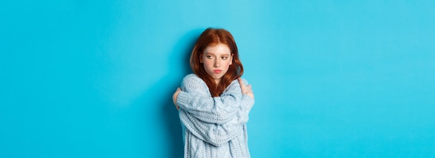 Free photo silly and cute redhead girl pucker lips and looking offended hugging herself and looking away offend