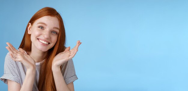 Silly cute sincere young european ginger girl blue eyes shrugging hold hands doubtful spread near