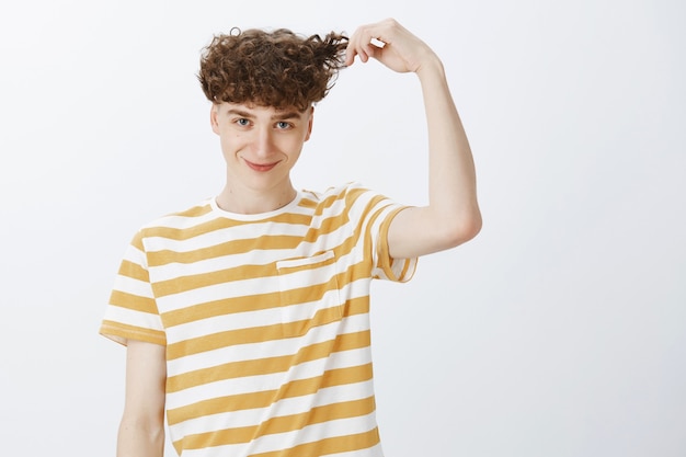 Free photo silly cute teenage guy posing against the white wall