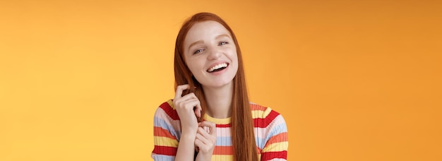 Free photo silly goodlooking flirty lively redhead young girl laughing playing coquettish ginger hair strand ch