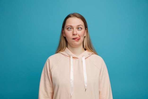 Silly young blonde woman showing tongue with crossed eyes 