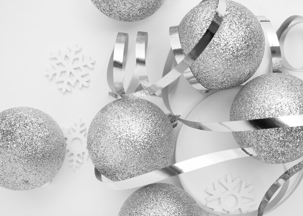 Серебряные рождественские украшения на белом столе