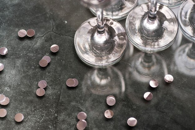 Silver confetti and wineglasses on concrete background