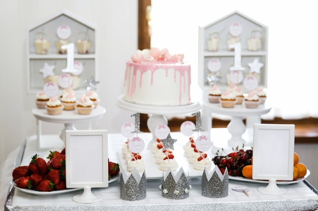 Серебряные короны стоят на столе с розовым хлебом и ягодами