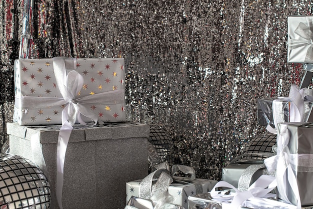 Foto gratuita scatole di natale festive d'argento su uno sfondo lucido.
