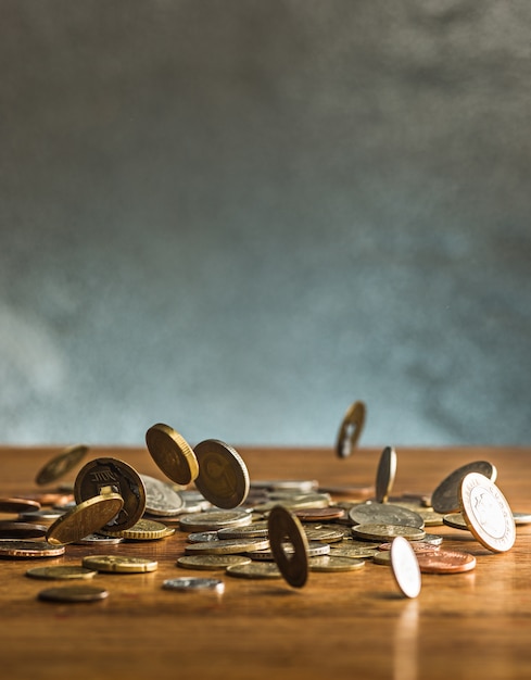 The silver and golden coins and falling coins on wooden background