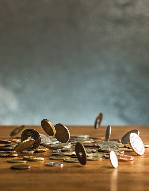 Серебряные и золотые монеты и падающие монеты на деревянном фоне