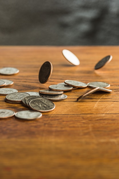 The silver and golden coins and falling coins on wooden background