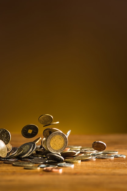 The silver and golden coins and falling coins on wooden table