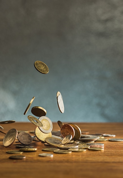 The silver and golden coins and falling coins on wooden