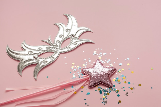 Бесплатное фото Серебряная маска с розовой звездой на палочке