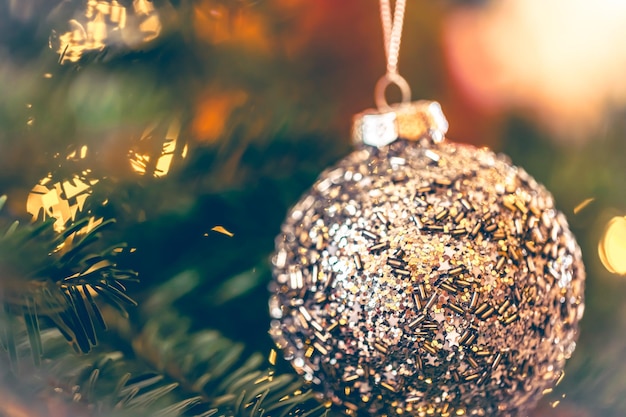 Silver shiny christmas ball on a christmas tree branch closeup