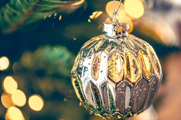 Silver shiny christmas ball on a christmas tree branch closeup