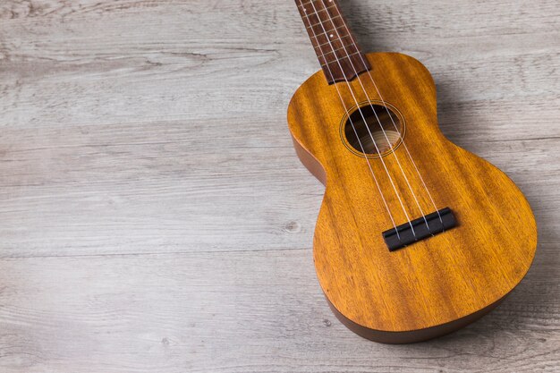 Simple classical wooden musical guitar on wooden background