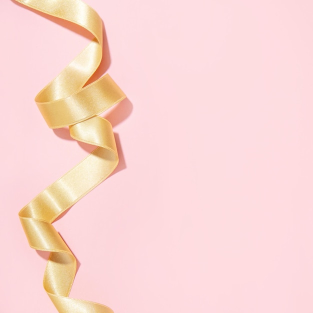 Simple golden ribbon on pink background