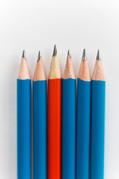 Simple pencils, one red among the blue