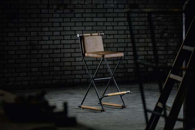 조명 아래 스튜디오에 있는 단순한 나무 이발용 의자