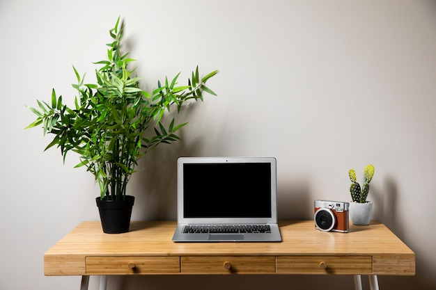 Free photo simple wooden desk with gray laptop