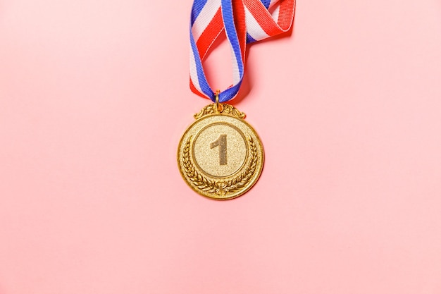 Simply flat lay design winner or champion gold trophy medal isolated on pink colorful background vic...