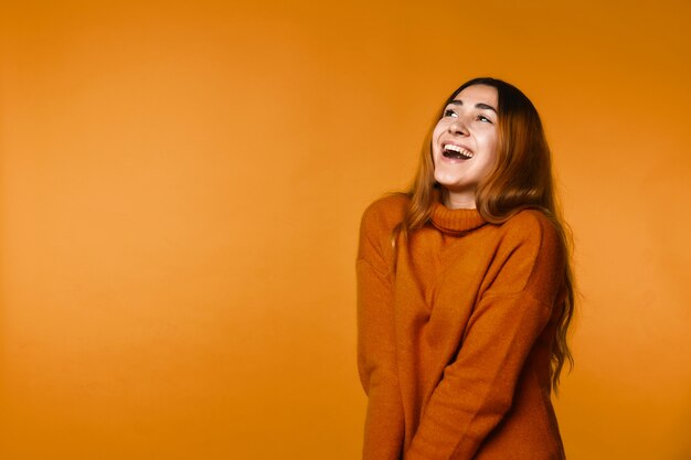 Sincerely smiling redhead caucasian woman dressed in wool pullover