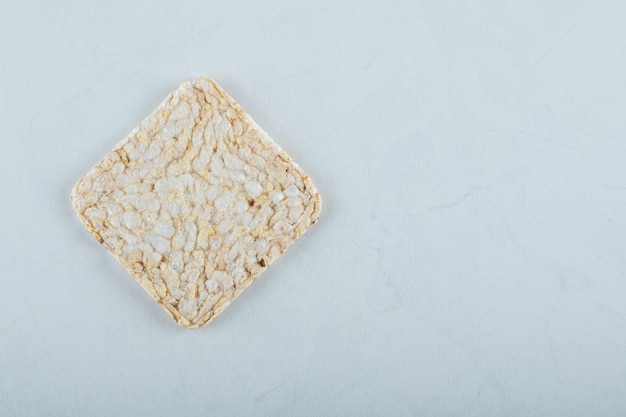 Single airy crispbread on white.