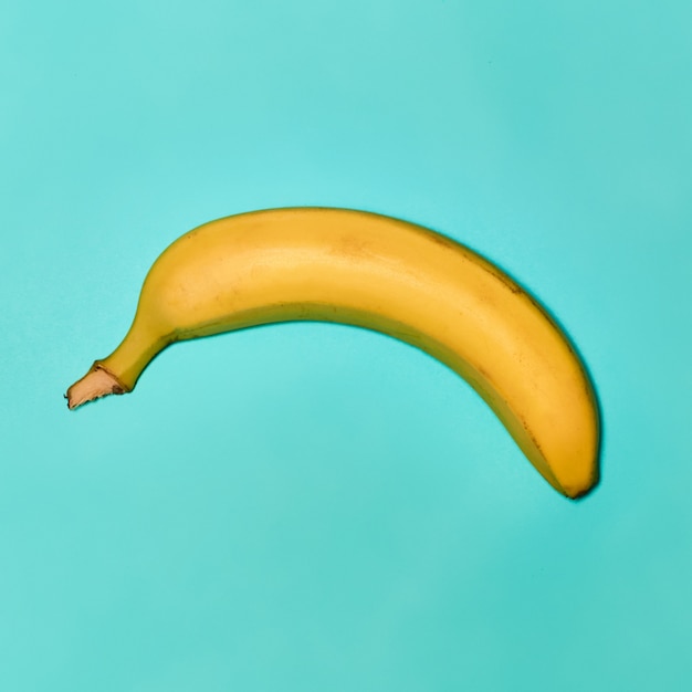 Singola banana su sfondo blu