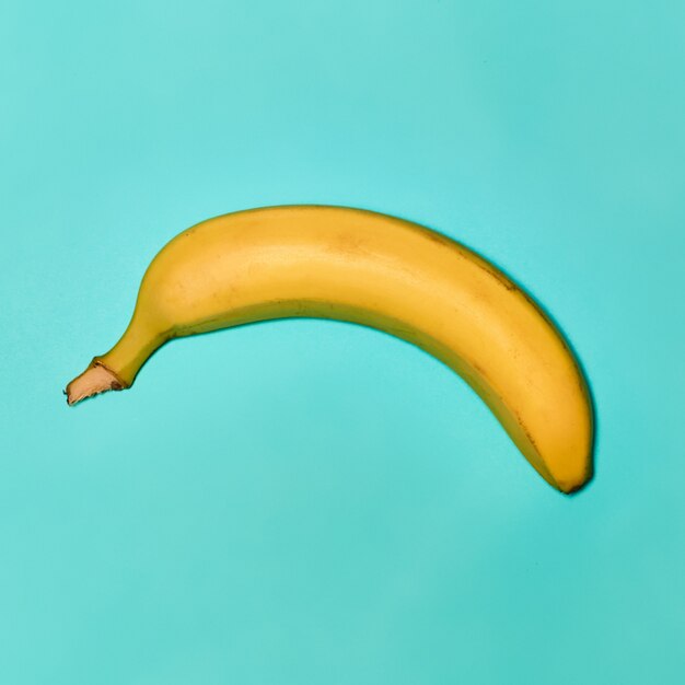 Один банан на синем фоне