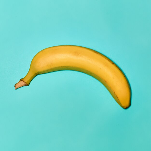 Single banana against blue background