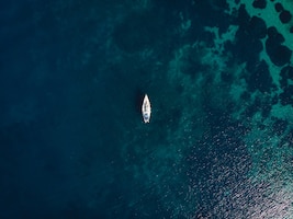 Бесплатное фото Одиночная лодка посреди чистого синего моря