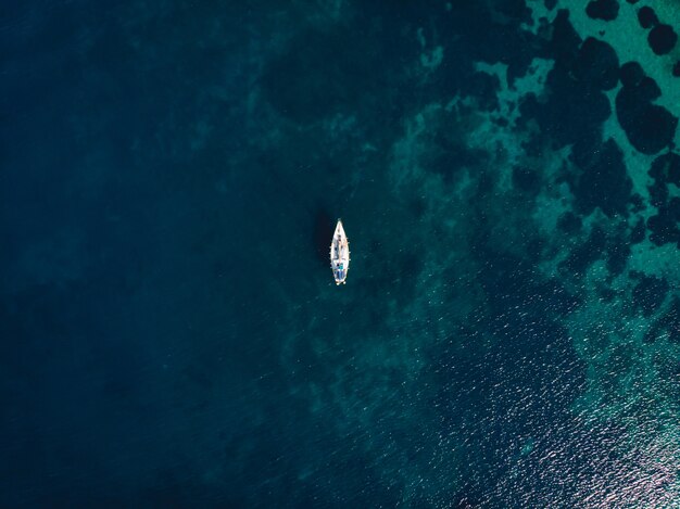 Single boat in the middle of clear blue sea