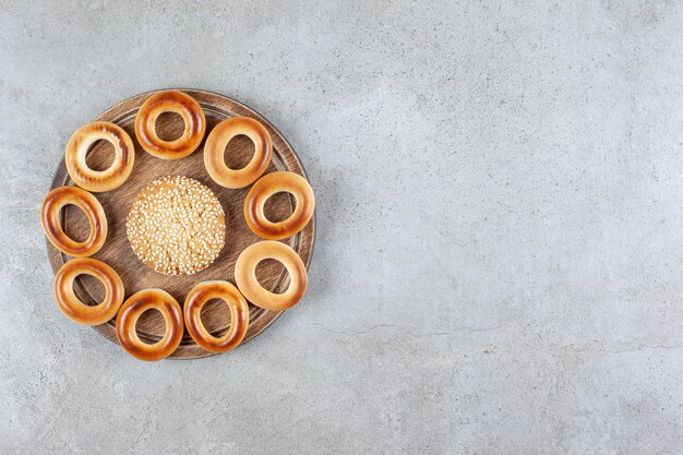 sushki 대리석 배경에 나무 보드에 둘러싸인 단일 쿠키. 고품질 사진