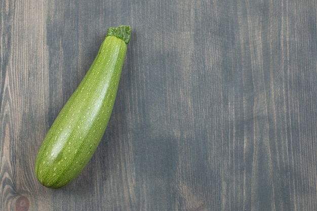 Single courgette or zucchini isolated on a wooden table